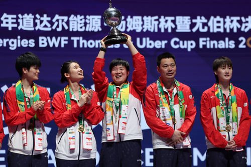 5月5日，中国队选手何冰娇（中）在颁奖仪式上高举尤伯杯奖杯。新华社记者 陈斌 摄
