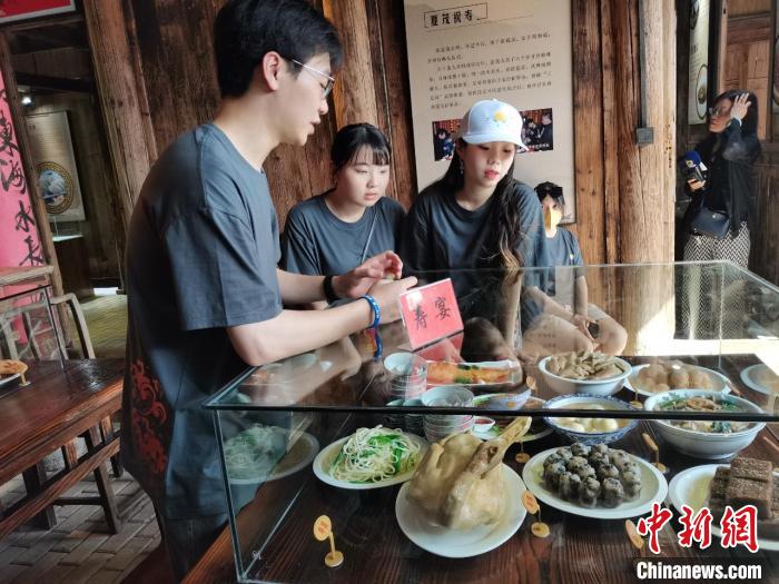 在特色小吃民俗文化馆内，夏茂镇青年为台湾青年介绍当地美食。黄艳摄