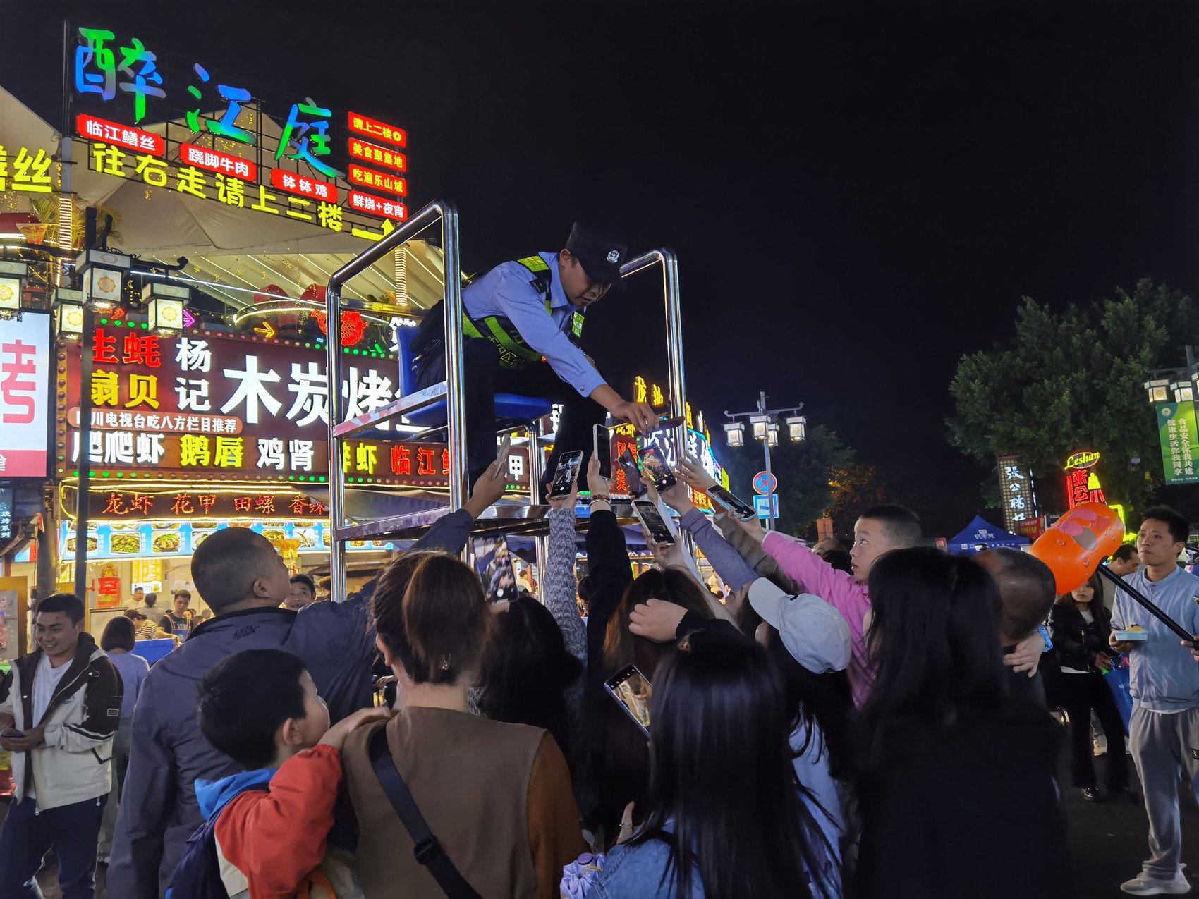 乐山张公桥好吃街执勤民警为游客代拍 乐山市公安局供图