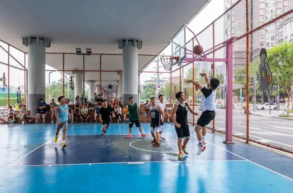 年轻人们在成都市府青路立交桥下的运动空间打篮球。图据新华社