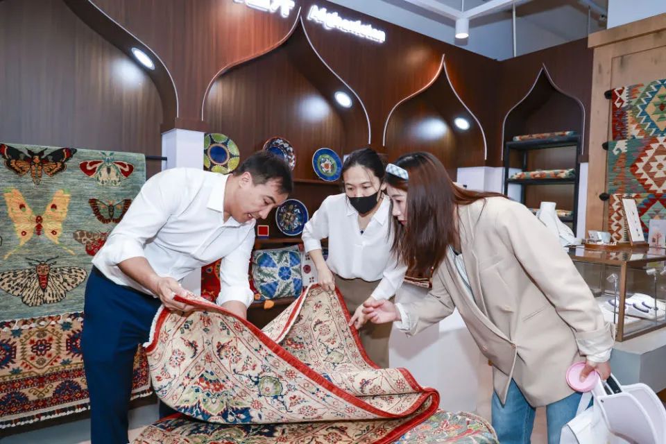 阿富汗客商阿里在进博集市城市会客厅内向游客介绍新品。受访者供图