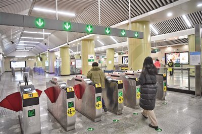 2023年1月8日，地铁14号线九龙山站，乘客刷卡进站。资料图片/新京报记者 王贵彬 摄