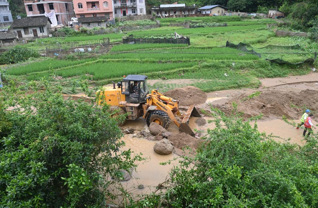 7日，在广西岑溪市波塘镇六肥村，工作人员在清理淤泥。新华社记者陆波岸 摄