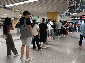 刚通关过来的香港人在货币兑换点等候换币 财联社记者摄