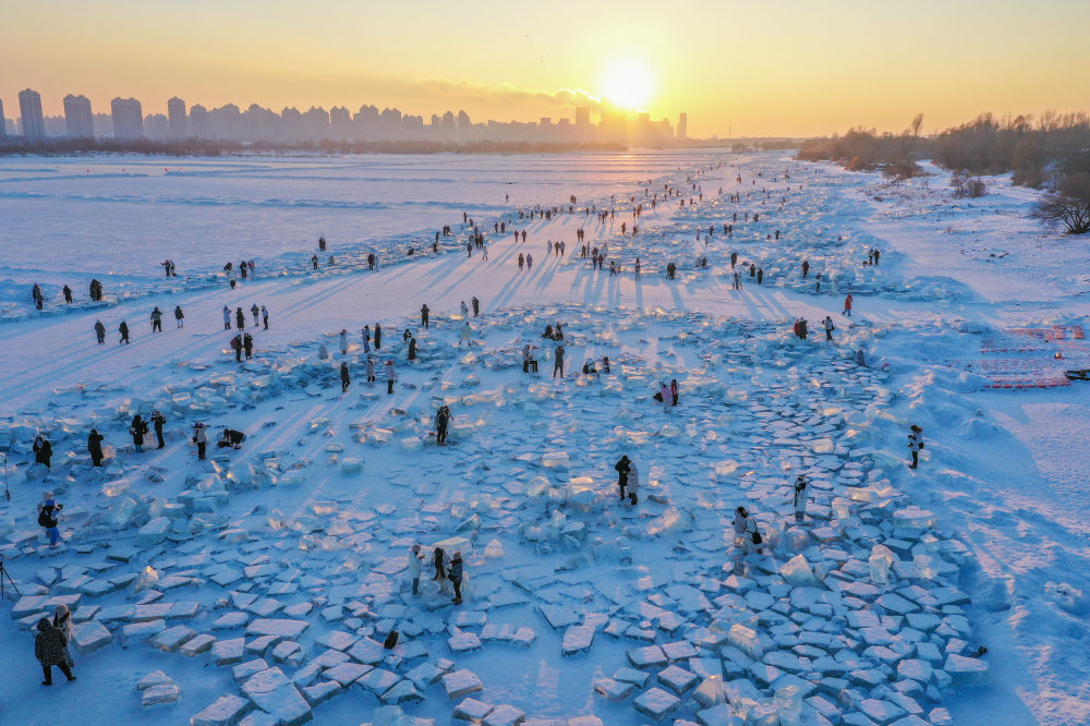 　2024年1月7日，在封冻的松花江哈尔滨段，游客在日落时分的“钻石海”游玩（无人机照片）。新华社记者谢剑飞摄