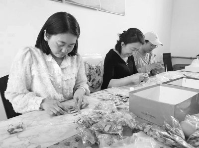 妇女在村内手工编织室进行彩绳编织.