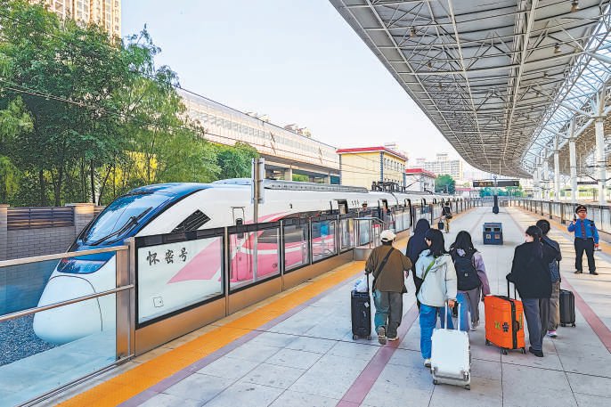 在北京北站，游客搭乘市郊铁路怀密线列车出游度假。 本报记者 邓伟摄