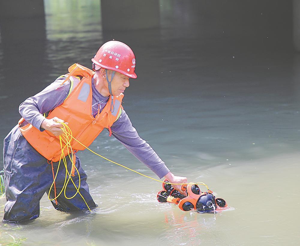 工作人员正在用水下机器人对桥梁进行检测