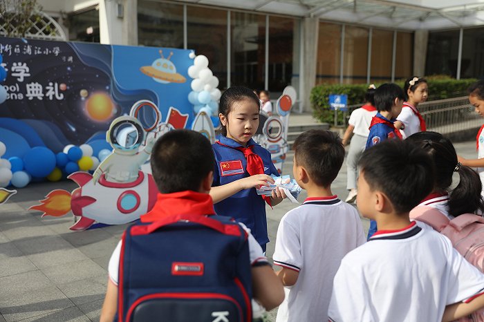 上海市闵行区浦汇小学：小小“航天员”向学生发放升级“登机”牌。上海市教委供图
