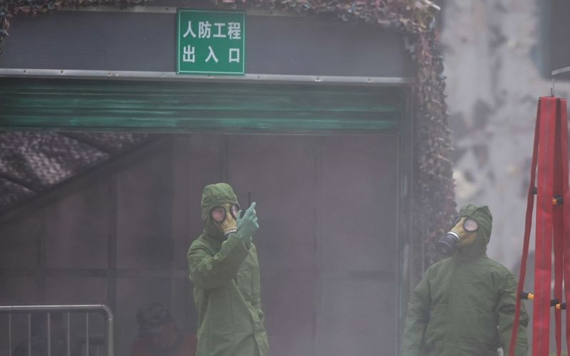 “空袭”结束后，身着防化服的志愿者使用仪器确认空气是否安全。  新京报记者 王子诚 摄