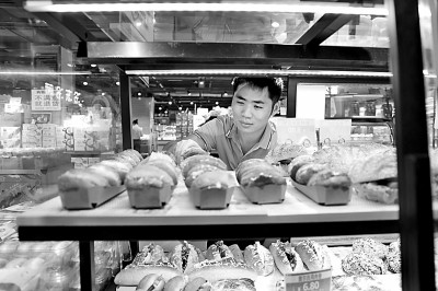     江西省赣州市全南县一面包店，顾客正在选购面包。 郭根平摄/光明图片