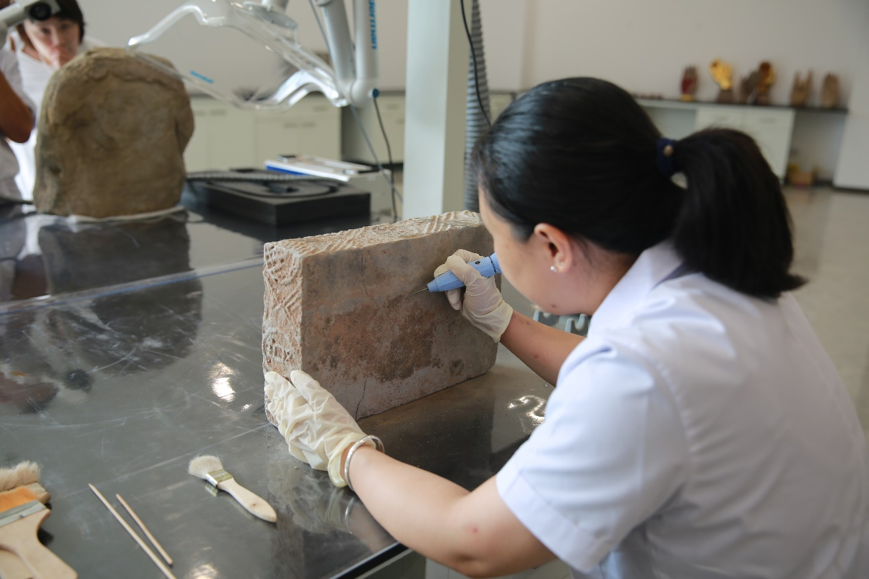 　　大足石刻文物医院内，工作人员正在修复文物。 活动主办方供图