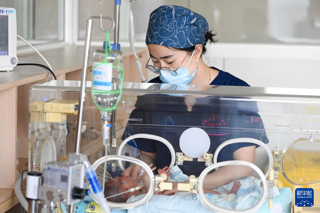 5月7日，新生儿科护士罗建华护理新生儿。新华社记者 张楠 摄