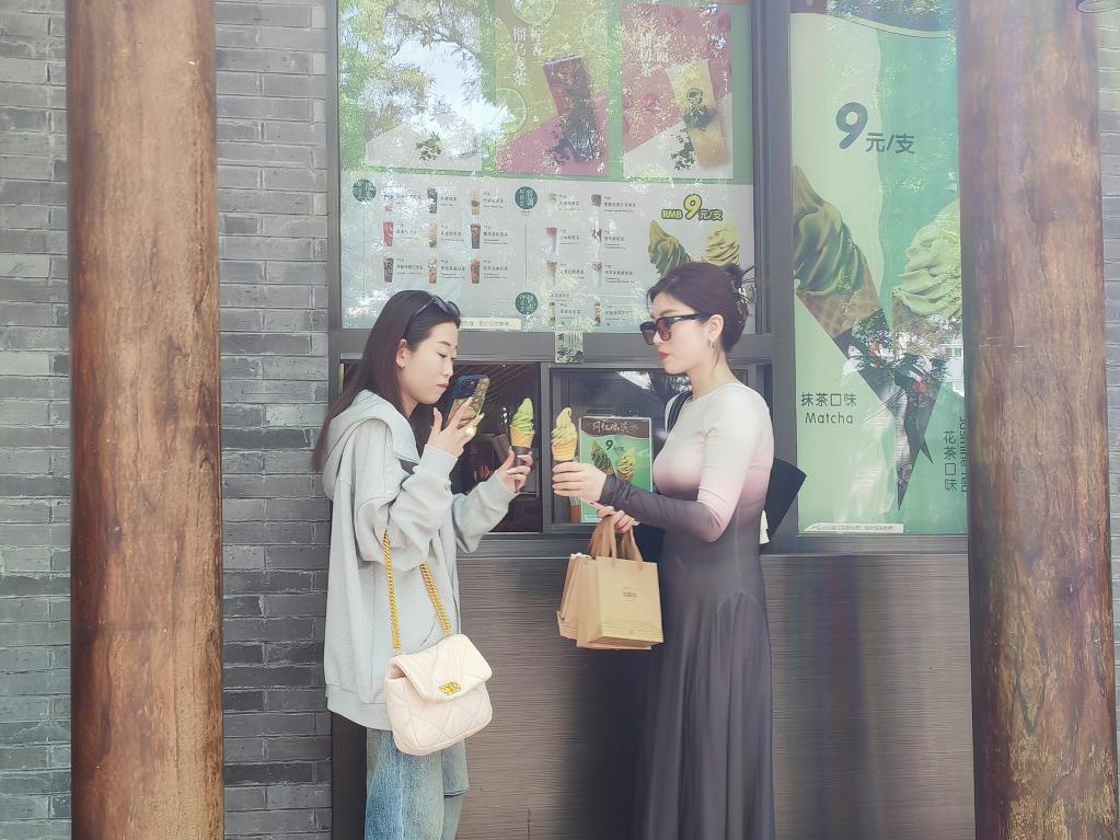 5月8日，位于东四大街的吴裕泰茶庄门口，两名女士在购买冰激凌。新华社记者谢希瑶 摄