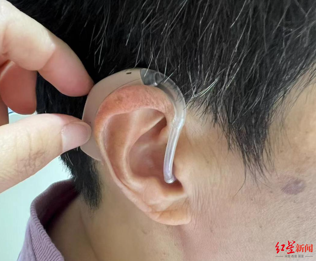 ▲听力障碍人士戴上助听器