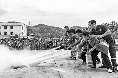 5月10日，蓝天救援队队员在贵州省黔西市锦星镇第二小学指导学生使用灭火器。新华社发