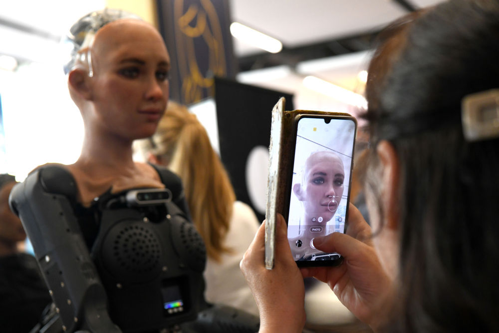 2023年7月7日，在瑞士日内瓦“人工智能造福人类全球峰会”上，一名参会者给仿真机器人索菲亚拍照。新华社记者 连漪 摄