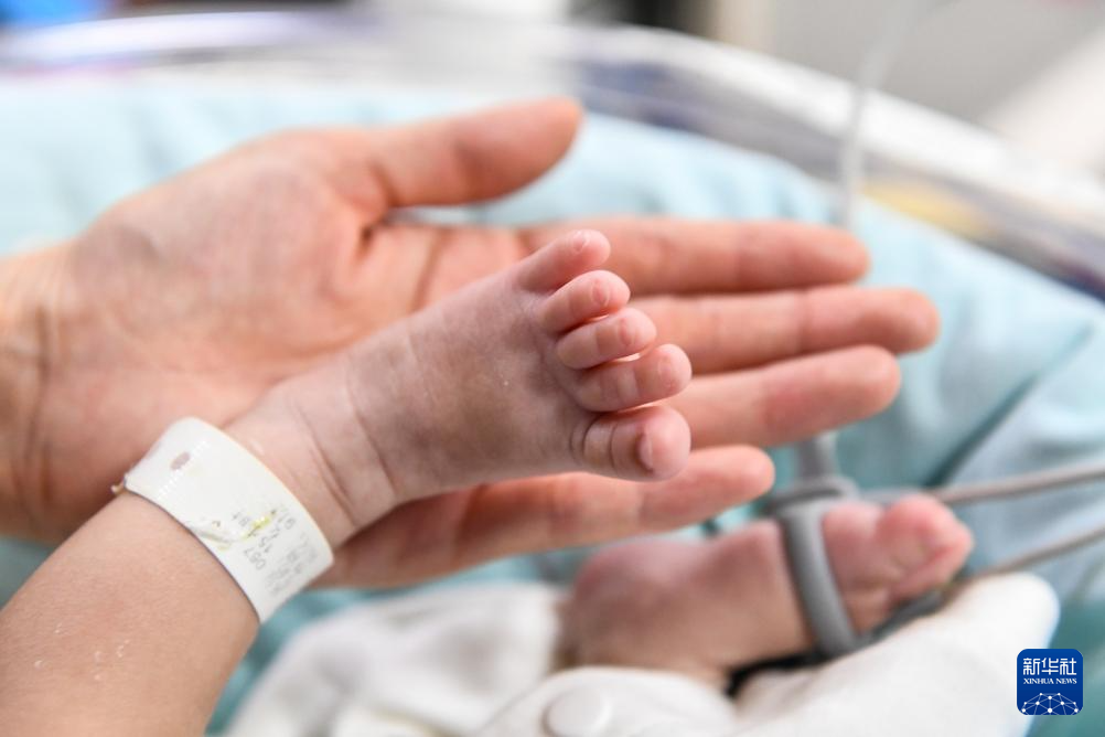 5月8日，新生儿科护士罗建华手捧新生儿小脚。新华社记者 张楠 摄