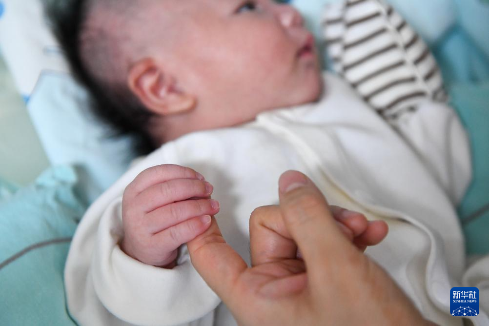 5月8日，新生儿科护士罗建华安抚新生儿情绪。新华社记者 张楠 摄
