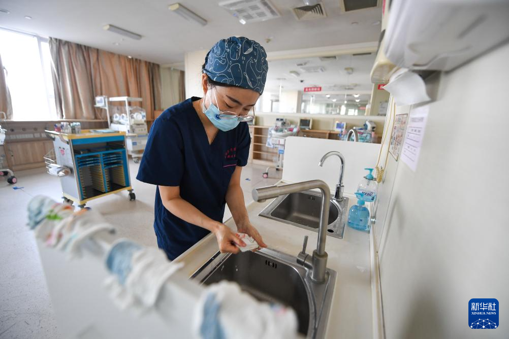5月7日，新生儿科护士罗建华给新生儿洗手套。新华社记者 张楠 摄