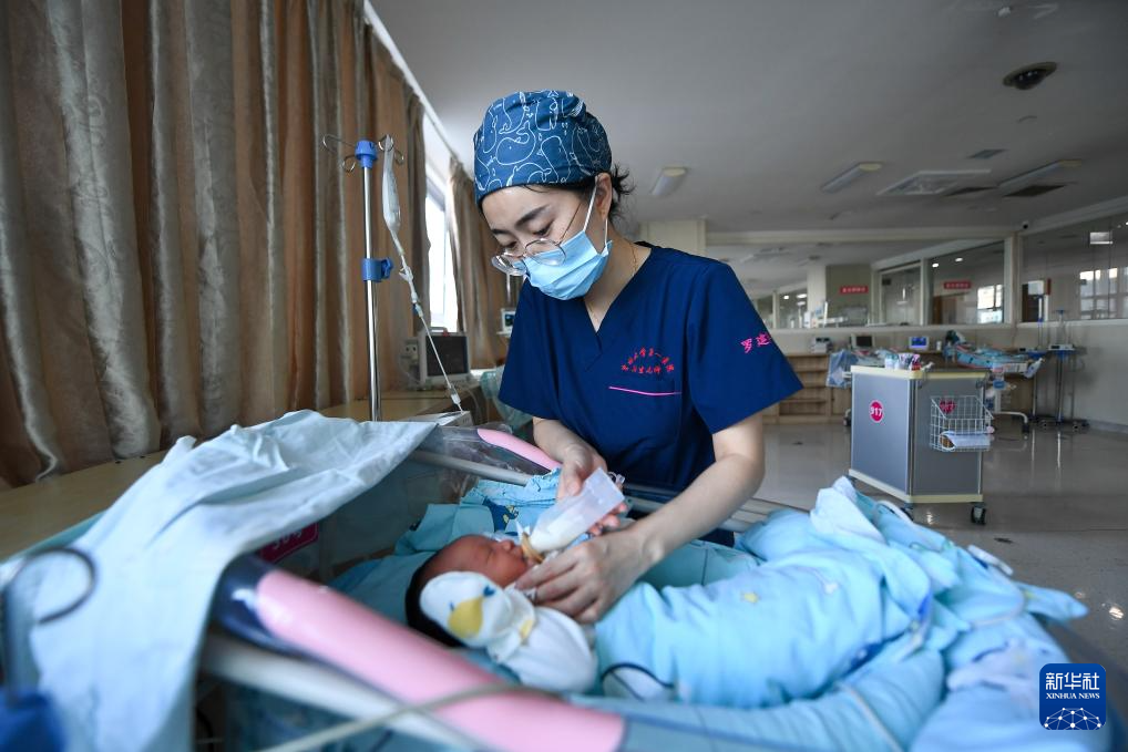 5月7日，新生儿科护士罗建华给新生儿喂奶。新华社记者 张楠 摄