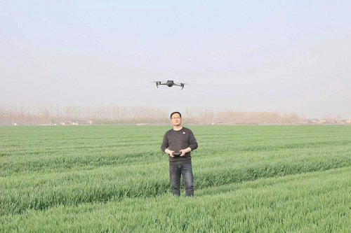   在江苏省新沂市马陵山镇陈楼村，技术人员正在用载有多光谱相机的无人机给小麦“拍片体检”。　郭欣昕　摄