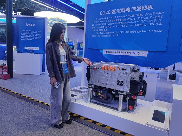 　　展区工作人员介绍G120氢燃料电池发动机。(曹晓敏 摄)