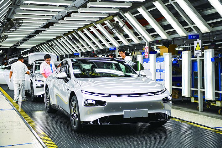 ▲小鹏汽车肇庆工厂的工作人员在查看整车（2023年10月9日摄）。