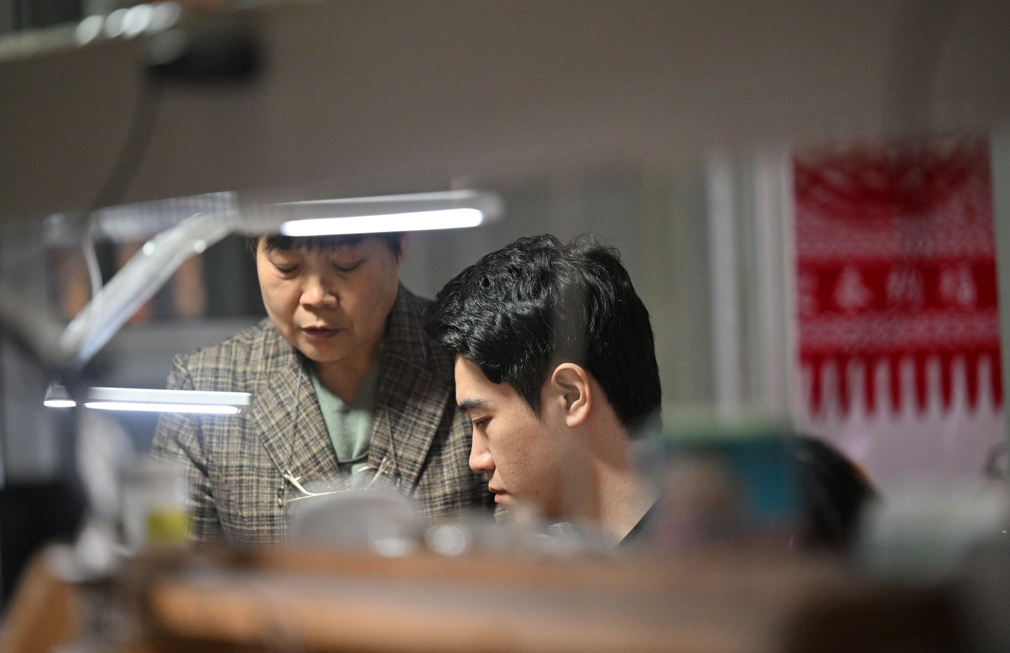 马赛（右）在工作室内和母亲交流制作技艺（3月19日摄）。新华社记者 李然 摄