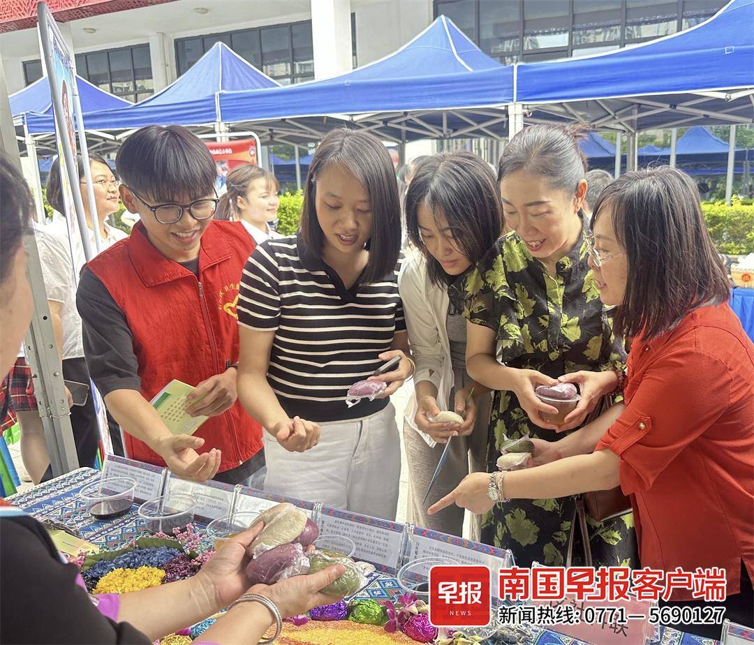 右江区社科联志愿者为市民讲解五色糯米饭及染料知识。
