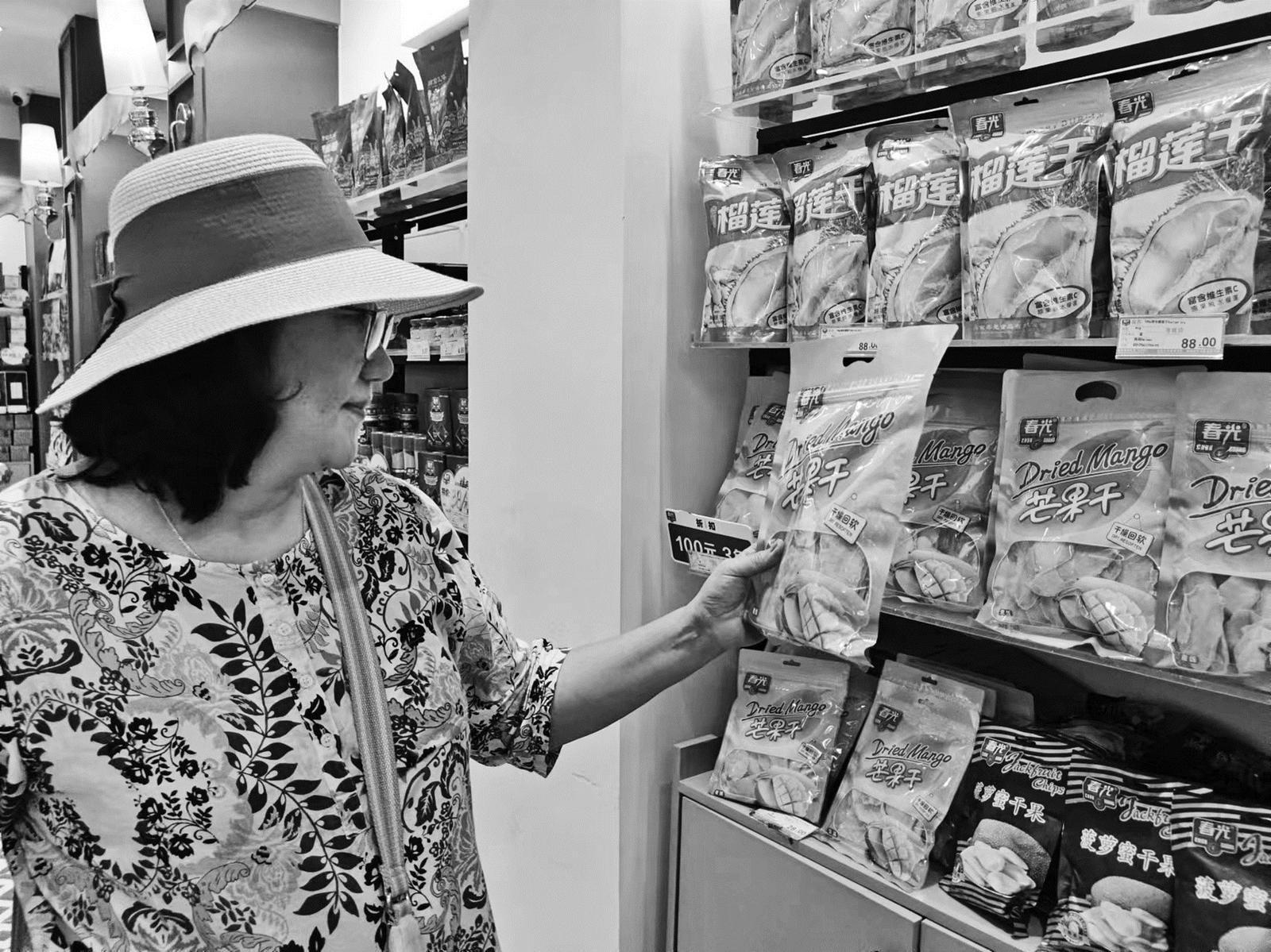 游客在春光·随时椰店铺购买手信□ 吴开诗 文/摄"这是我们研发的海盐