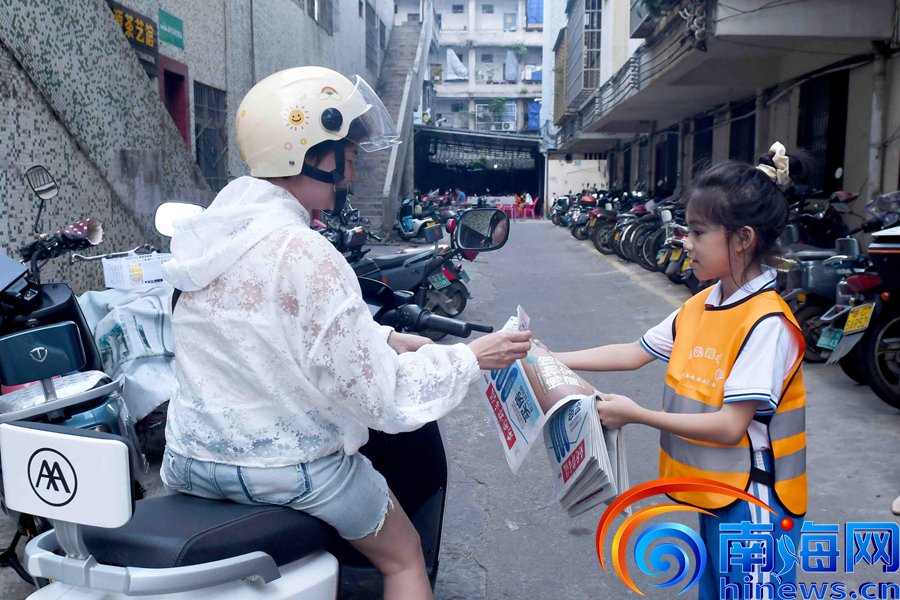　　澄迈县第二小学四（1）班学生黄如仙（右）向路人推销报纸。记者 蒙健 摄