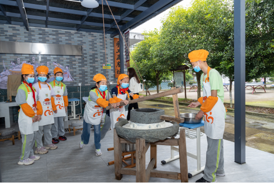 大墅镇中心小学学生们在豆腐工坊实践用石磨磨豆浆