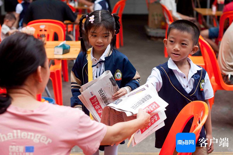 　　孩子们向路人售卖报纸。记者蒙健 摄