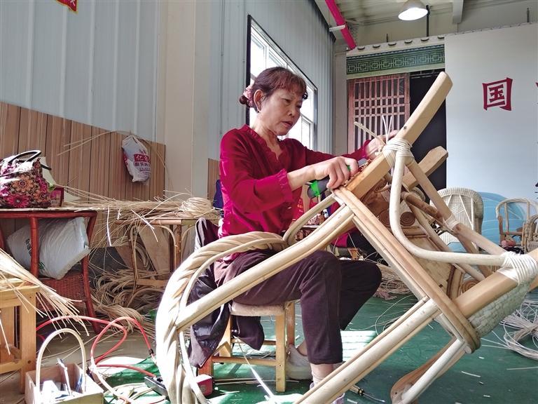 5月15日,在汉中市南郑区,陕西良顺匠心实业有限公司手艺人在编藤椅.