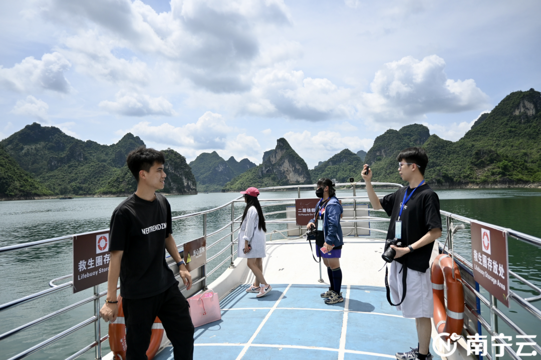 网络名人乘船游览大龙湖，拍照记录秀美的自然风光。记者 陈艳华 摄