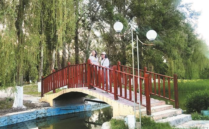 5月15日,在六师五家渠市滨河公园,市民在驻足观赏美景.