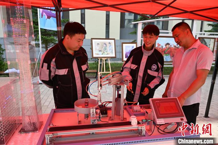 胡春晖(中)与老师和同学交流仪器设备操作。中新网记者刘文华摄