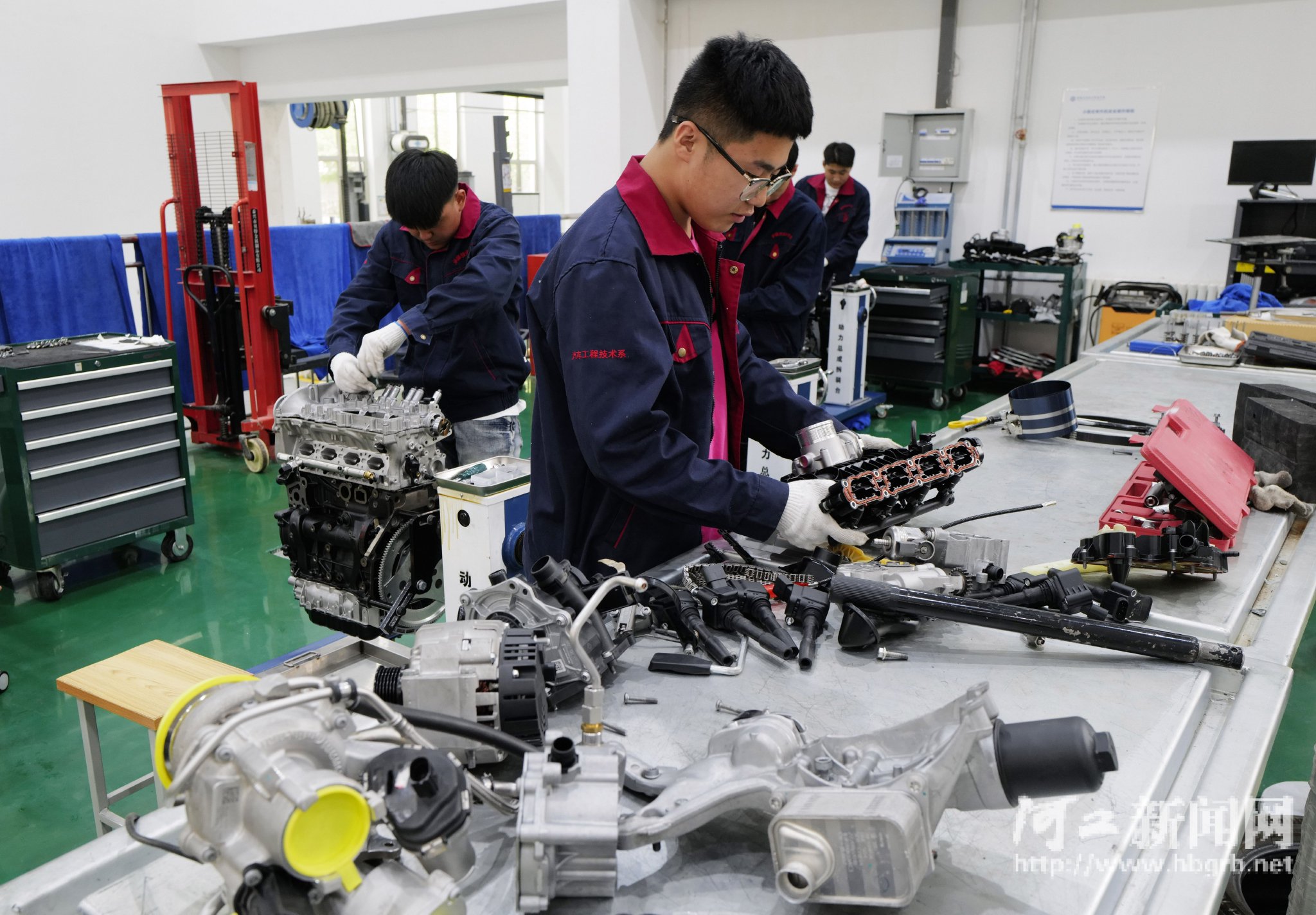 学生们在对汽车零部件进行拆分组装练习.