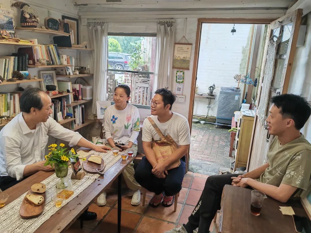 在桂南村旗溪自然村,郭文海走访沿街店铺,驻足"网红店"丹娜咖啡馆,与