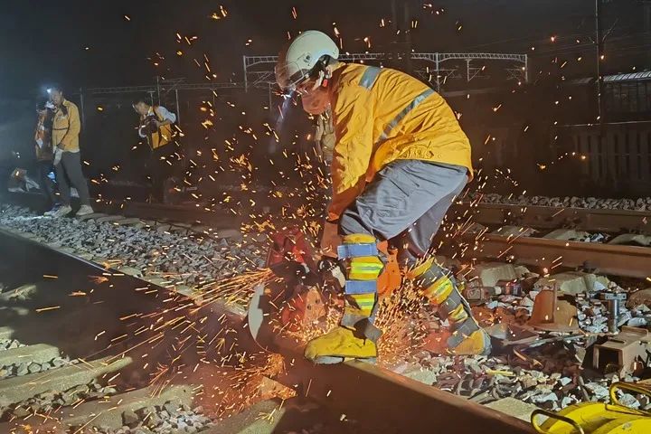 在宁启铁路海安站北面岔区,铁路养护工人在切割钢轨.