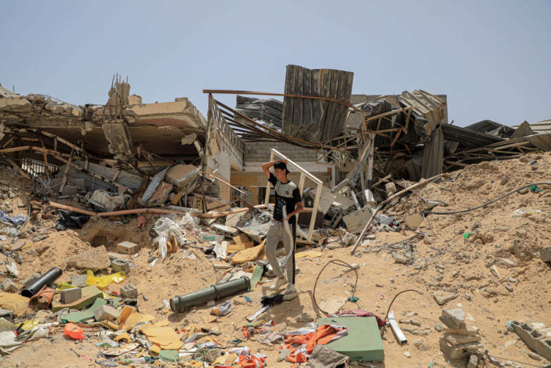 5月21日，在加沙地带南部城市汗尤尼斯，巴勒斯坦东说念主在废地中捡拾物品。新华社发（里泽克·阿卜杜勒贾瓦德摄）