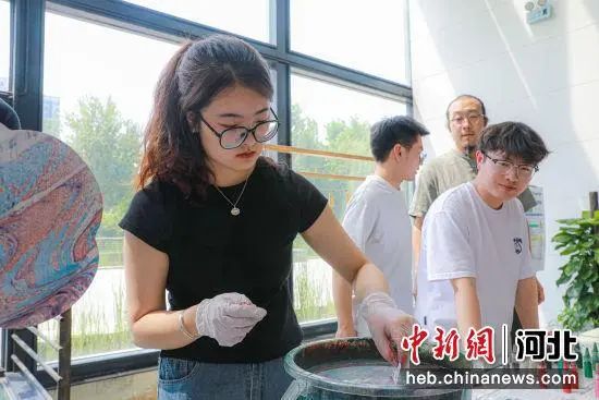 "正在体验"漂流漆扇"制作的市民王茜感叹道.