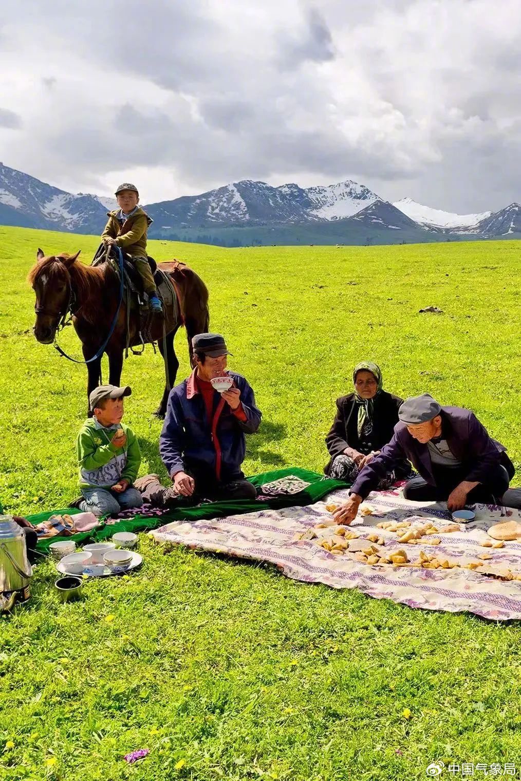 哈萨克牧民一家老小围坐,喝奶茶吃包尔萨克 来源:人民日报 摄影:赖宇