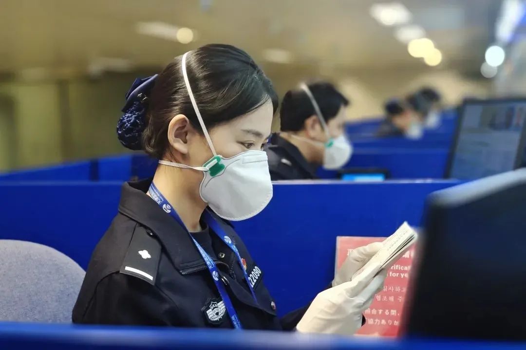 天津机场边检站移民管理警察为入境旅客办理边检手续。（曹岚 摄）