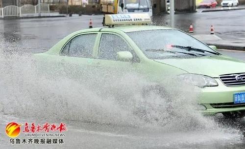 汽车驶过积水路面（资料图片）。来源：乌鲁木齐晚报