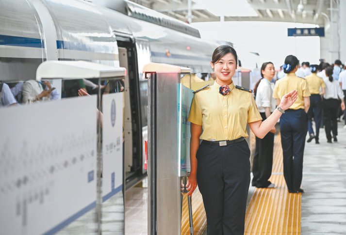 图为乘务人员在佛莞城际铁路东莞麻涌站指引乘客.