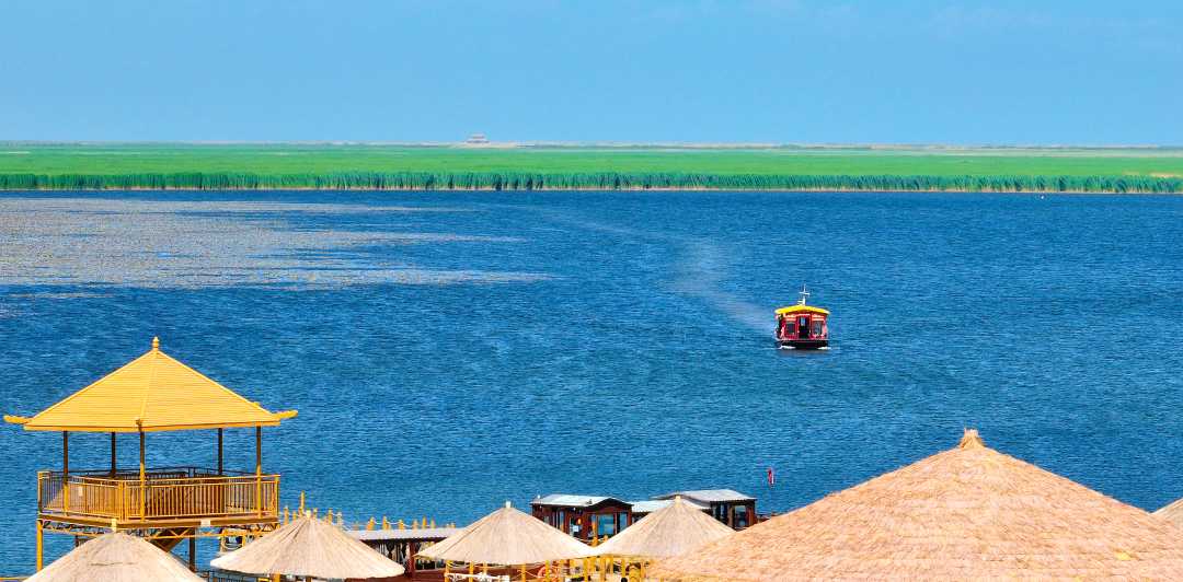 6月3日,游客乘坐画舫船畅游博斯腾湖莲海世界景区.