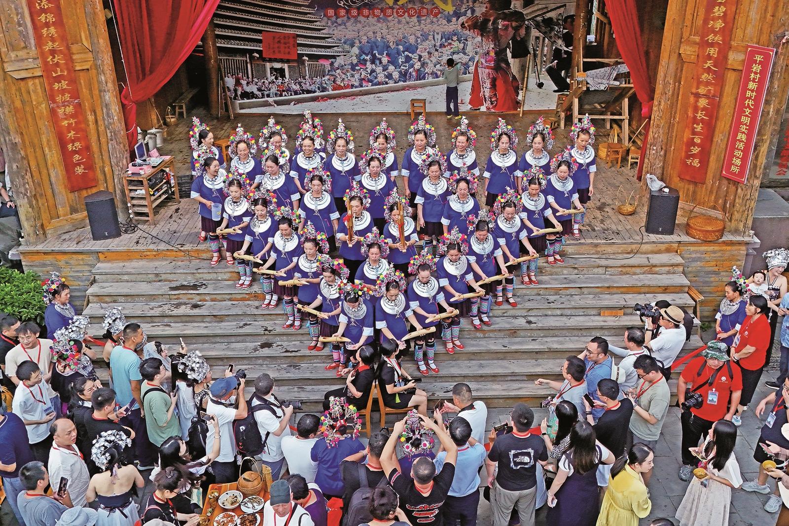 在广西三月三长桌宴活动中,游客体验"高山流水"敬酒仪式 本报记者