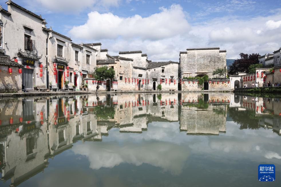 夏日里,在安徽省黄山市黟县宏村,徽派建筑和绿意盎然的自然环境交相